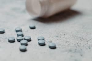 blue pills and canister on concrete background